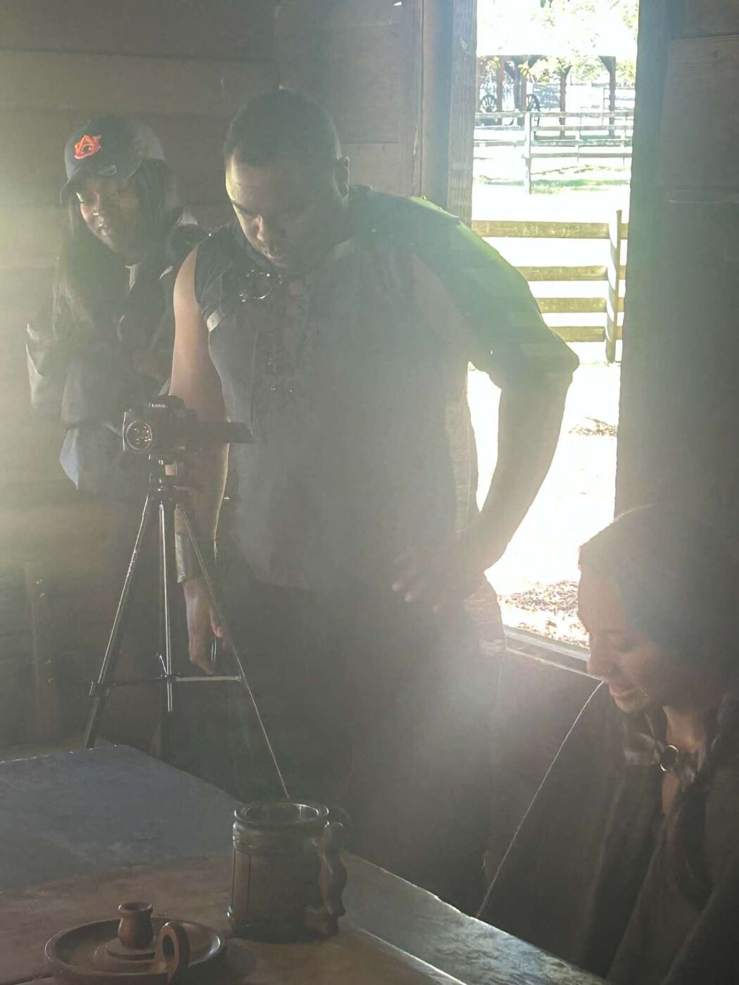 An actor in armor checking a shot beside the camera with crew inside the cabin