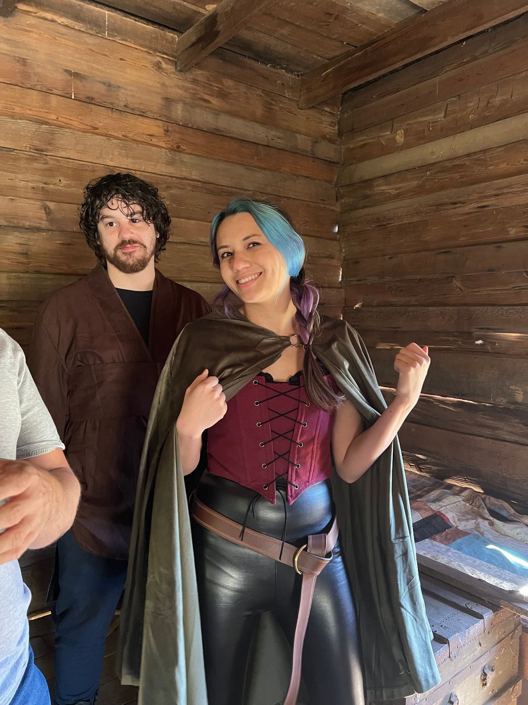 Two costumed cast members smiling together in a cabin corner