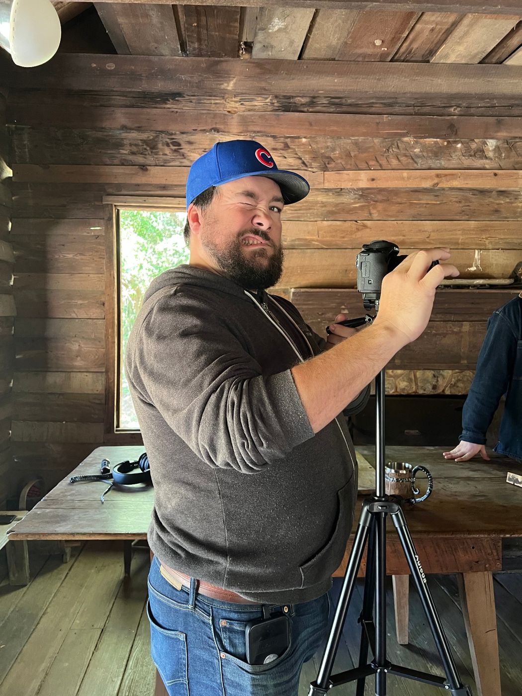 A crew member adjusting a camera on a tripod inside the cabin